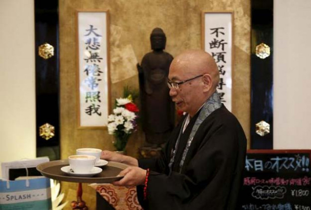 shokyo miura a buddhist monk and one of the on site priests carries cups of coffee past a statue of buddha at tera cafe in tokyo japan april 1 2016 photo reuters shokyo miura a buddhist monk and one of the on site priests carries cups of coffee past a statue of buddha at tera cafe in tokyo japan april 1 2016 photo reuters