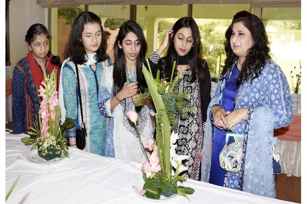 women keenly looking at the flowers during the exhibition photo inp women keenly looking at the flowers during the exhibition photo inp