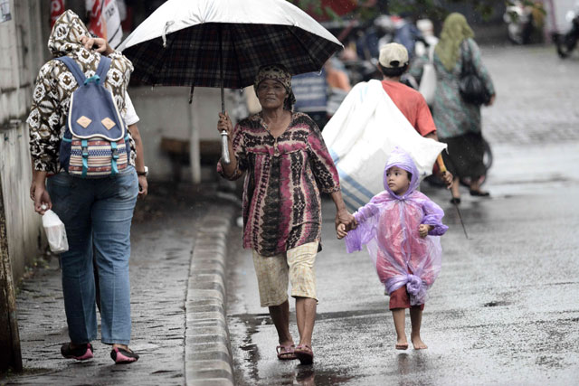 this picture taken on march 31 2016 shows a quot jockeys quot a women with a child who act as passengers for hire in exchange for a small fee along a street during rush hour in jakarta at rush hour every weekday women with babies slung across their arms line the traffic choked streets of the indonesian capital flagging down drivers looking to game jakarta 039 s carpooling laws by hiring a few extra passengers but revelations some of the infants used in this years old streetside business have been rented out by criminal syndicates and even drugged to keep them quiet has outraged jakartans and prompted a crackdown by city authorities photo afp