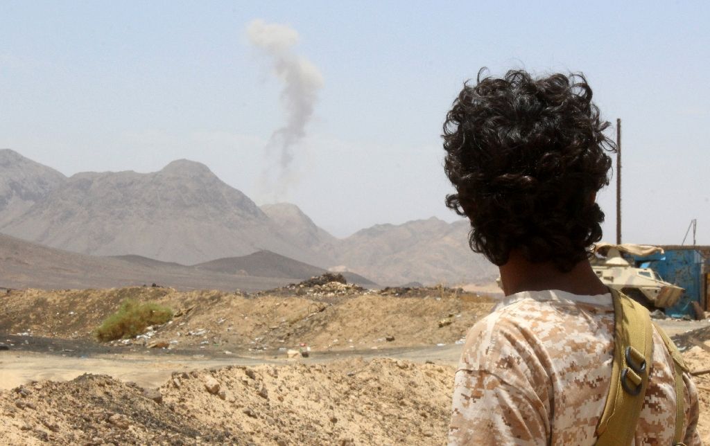 a yemeni fighter loyal to exiled president abedrabbo mansour hadi looks at smoke rising in the distance in the sirwah area in marib province on april 10 2016 photo afp