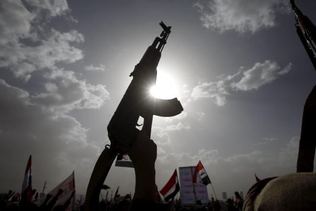 a houthi follower rises a weapon as he attends a rally marking one year of saudi led air strikes in yemen 039 s capital sanaa march 26 2016 photo reuters