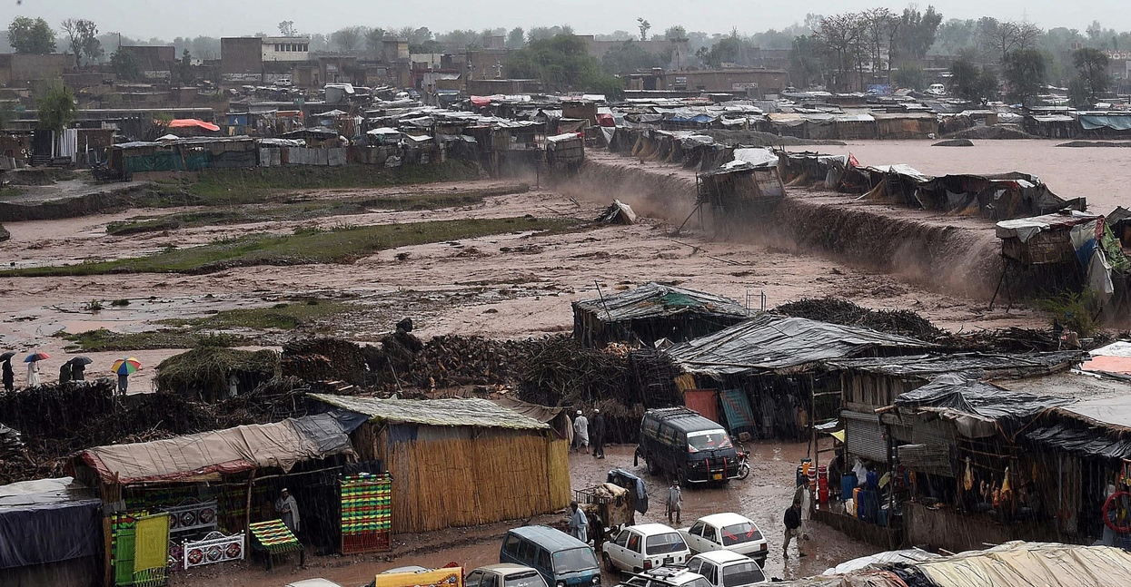 flood waters rush through a market area as vendors and resident scramble to save their possessions on the outskirts of peshawar on april 3 2016 photo afp