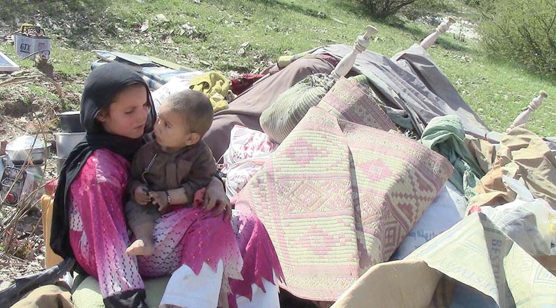 girl sits amid debris of a demolished house photo inp