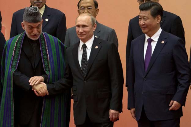 russian president vladimir putin c shakes hands with afghanistan s president hamid karzai l as chinese president xi jinping looks on during a group photo for the fourth summit of the conference on interaction and confidence building measures in asia cica in shanghai may 20 2014 photo reuters