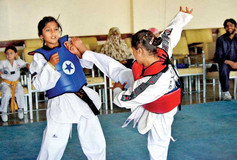 girls compete in taekwondo match during the event photo inp