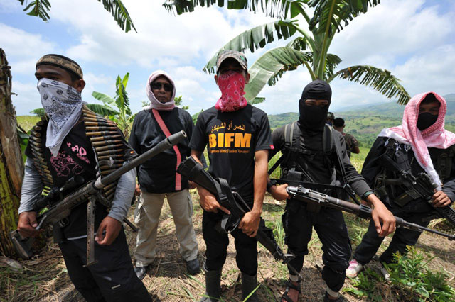 this file photo shows members of a breakaway muslim separatist group stand guard during a clandestine press conference in the town of datu unsay sothern maguindanao province in the philippines on august 28 2011 photo afp