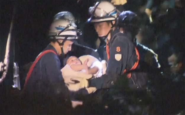 the baby is carried away by rescue workers photo aptn via telegraph