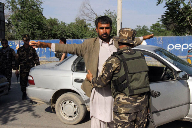 afghan security personnel search commuters at a checkpoint in kunduz province on april 15 2016 photo afp