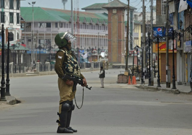 an indian paramilitary trooper stands guard during a tense curfew in srinagar on april 15 2016 photo afp