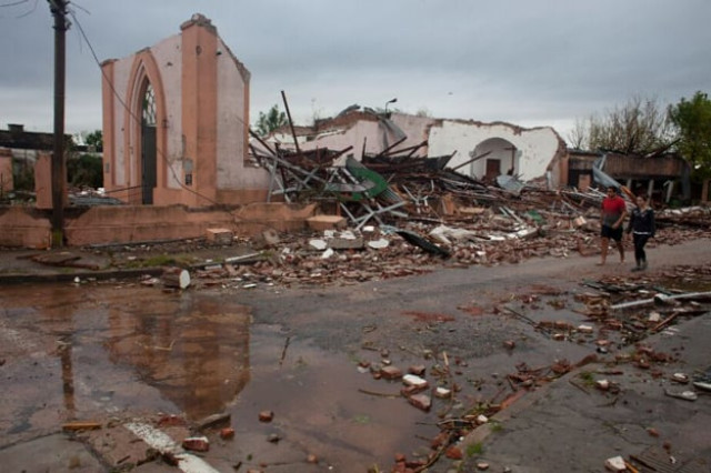people walk past the remains of a church hit by a tornado in dolores uruguay on april 16 2016 photo afp people walk past the remains of a church hit by a tornado in dolores uruguay on april 16 2016 photo afp