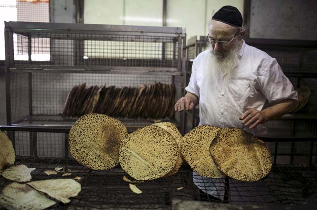 an ultra  orthodox jew inspects freshly baked matza the traditional unleavened bread eaten during the jewish holiday of passover in bnei brak in this file photo taken march 30 2015 photo reuters