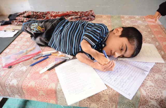 abdul baqi 16 lies on a table for his class nine board exams in lyari on monday his physical disability does not allow him to sit up or walk photo mohammad azeem express abdul baqi 16 lies on a table for his class nine board exams in lyari on monday his physical disability does not allow him to sit up or walk photo mohammad azeem express
