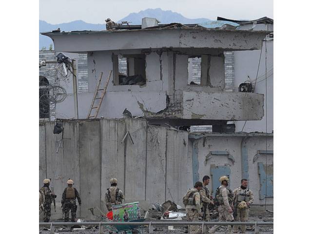 afghan security personnel inspect the site of a car bomb attack at the gate of a government office in the puli mahmood khan neighbourhood of kabul on april 19 2016 photo afp