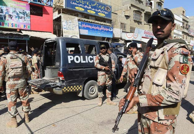 pakistani security personnel gather around a police van after an attack by gunmen on security members guarding a polio vaccination team in karachi on april 20 2016 photo afp