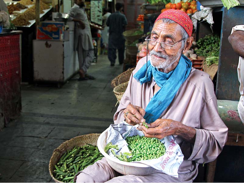 eighty year old muhammad hassan who cannot see has been sitting at the main gate of empress market for the last 35 years he shells the peas of vegetable vendors and sells matchboxes earning rs300 per day photo aysha saleem express