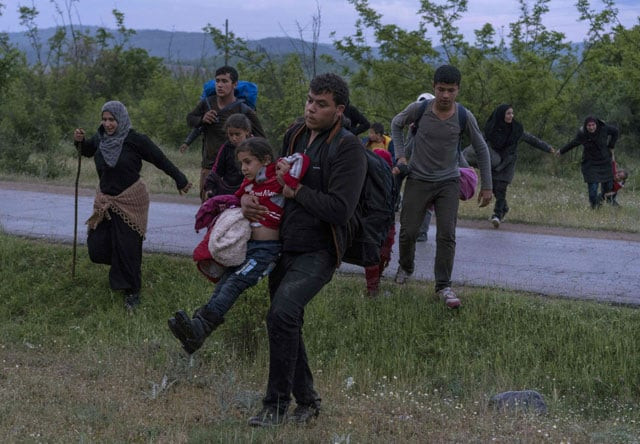 syrian refugees cross a road with their children while on the run in a forest in macedonia after illegally crossing greek macedonian border near the city of gevgelija on april 23 2016 photo afp syrian refugees cross a road with their children while on the run in a forest in macedonia after illegally crossing greek macedonian border near the city of gevgelija on april 23 2016 photo afp