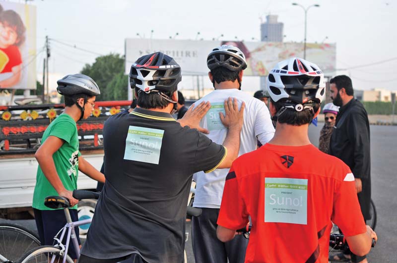 participants paste stickers of upcoming play suno on the backs of each other s shirts photo courtesy taskeen