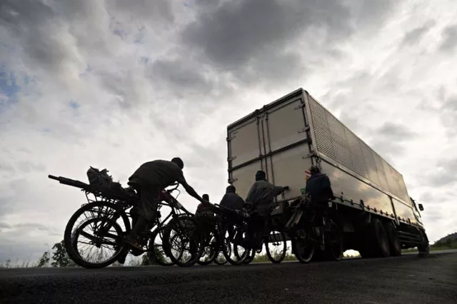 bicycle transporters hang onto the back of a truck riding in burundi 039 s capital bujumbura photo afp bicycle transporters hang onto the back of a truck riding in burundi 039 s capital bujumbura photo afp