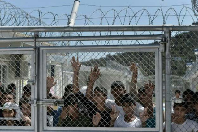 young migrants and refugees at a fence in the moria detention center on the greek island of lesbos on april 16 2016 photo afp young migrants and refugees at a fence in the moria detention center on the greek island of lesbos on april 16 2016 photo afp