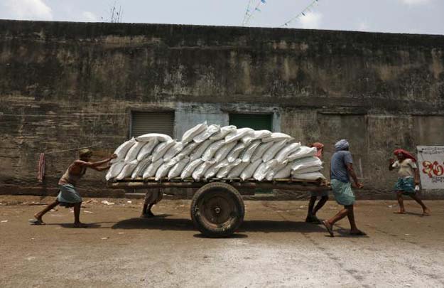 labourers push a handcart loaded with sacks of sugar at a wholesale market in kolkata india april 26 2016 photo reuters