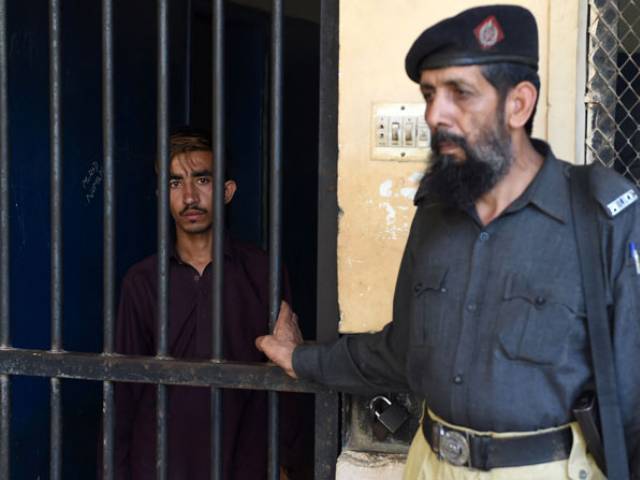 hayat khan an alleged killer of his sister l stands in a lockup at a police station in karachi on april 28 2016 photo afp