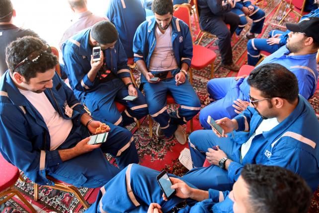 kuwait oil and petrochemical industries union workers sit with their cellphones on the first day of an official strike over public sector pay reforms in ahmadi kuwait april 17 2016 photo reuters