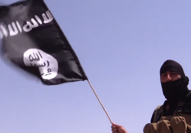 an islamic state terrorist holds a flag with the group 039 s flag photo reuters