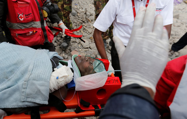 kenya red cross rescuers evacuate a woman from the rubble of a six storey building that collapsed last friday after days of heavy rain in nairobi kenya may 5 2016 photo reuters