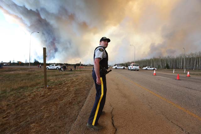 canadians drive through burning city seeking safety