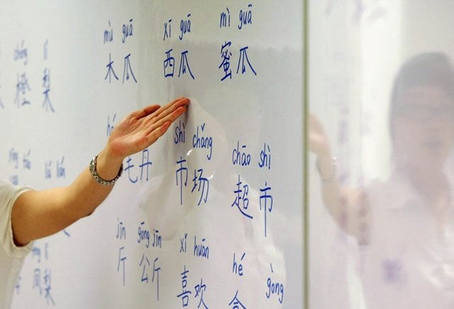 an instructor points out mandarin characters on a whiteboard at a night class for people learning mandarin as a second language in singapore september 1 2009 photo reuters