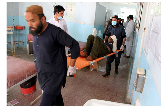 people transfer an injured man after 73 were killed in a three vehicle traffic accident in afghanistan photo inp