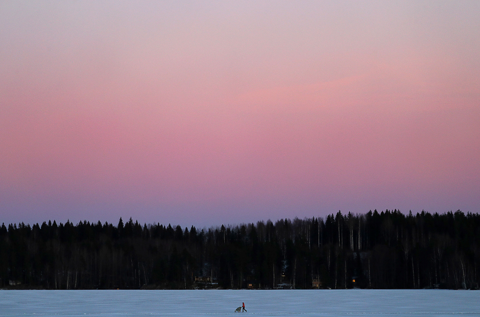 A woman pushes a pram as she walks over a frozen lake during sun down at the Pajulahti sports centre near Lahti, Finland. PHOTO: REUTERS 