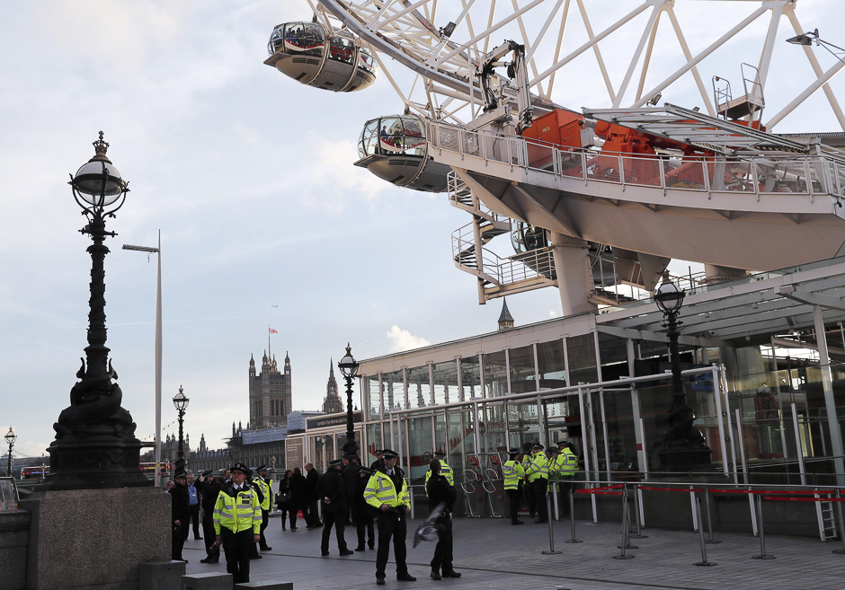 Police officers stand by as people are escorted off the pods of the London Eye after it was stopped following the attack. PHOTO: REUTERS