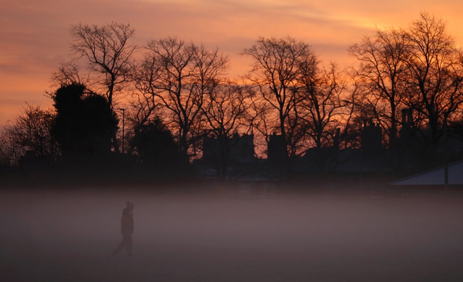 A woman walks through early morning mist in Knutsford, northern England December 5, 2016. REUTERS/Phil Noble