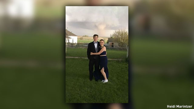 the couple posed for photos in a backyard with the tornado in the background photo oddity