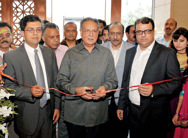 top left information minister pervaiz rashid cuts the ribbon for the express education and career expo alongside express media group ceo aijazul haq and director marketing azfar nizami right crowds gather at various stalls set up at the expo photo express