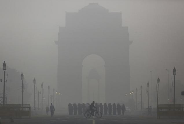 a man rides his bicycle next to indian soldiers marching in front of india gate on a smoggy morning in new delhi india december 1 2015 photo reuters