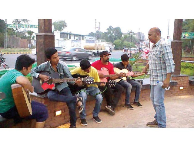 guitarist ustad sajjad tafu giving guitar lessons to aspiring musicians at liberty chowk photo file guitarist ustad sajjad tafu giving guitar lessons to aspiring musicians at liberty chowk photo file