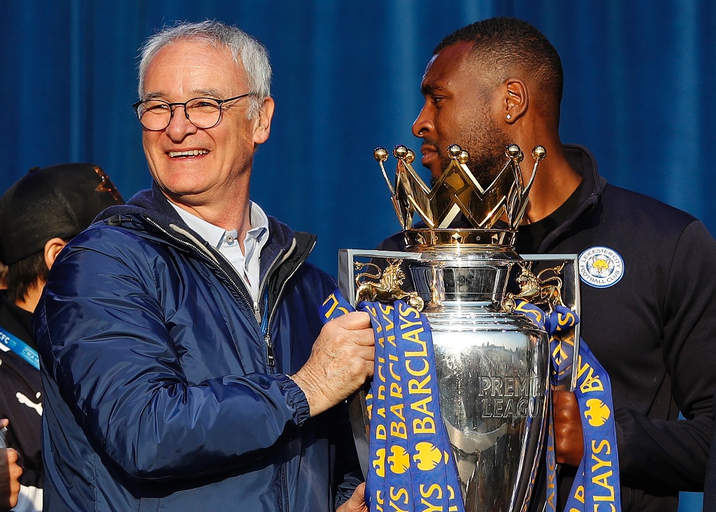 claudio ranieri l and wes morgan hold premier league trophy as leicester city football team celebrate in victoria park on may 16 2016 photo afp