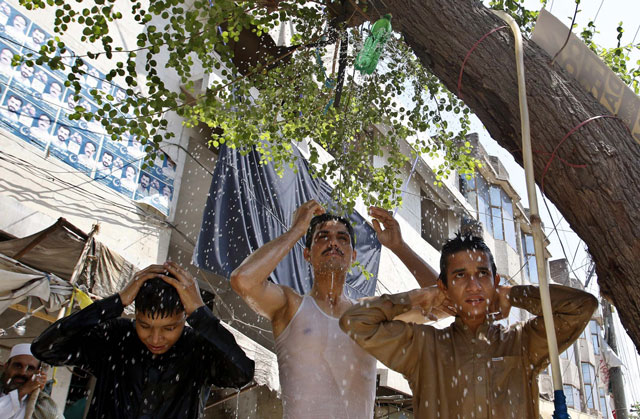 people cool off under a shower in peshawar on sunday as mercury rose to 43 degree c photo ppi