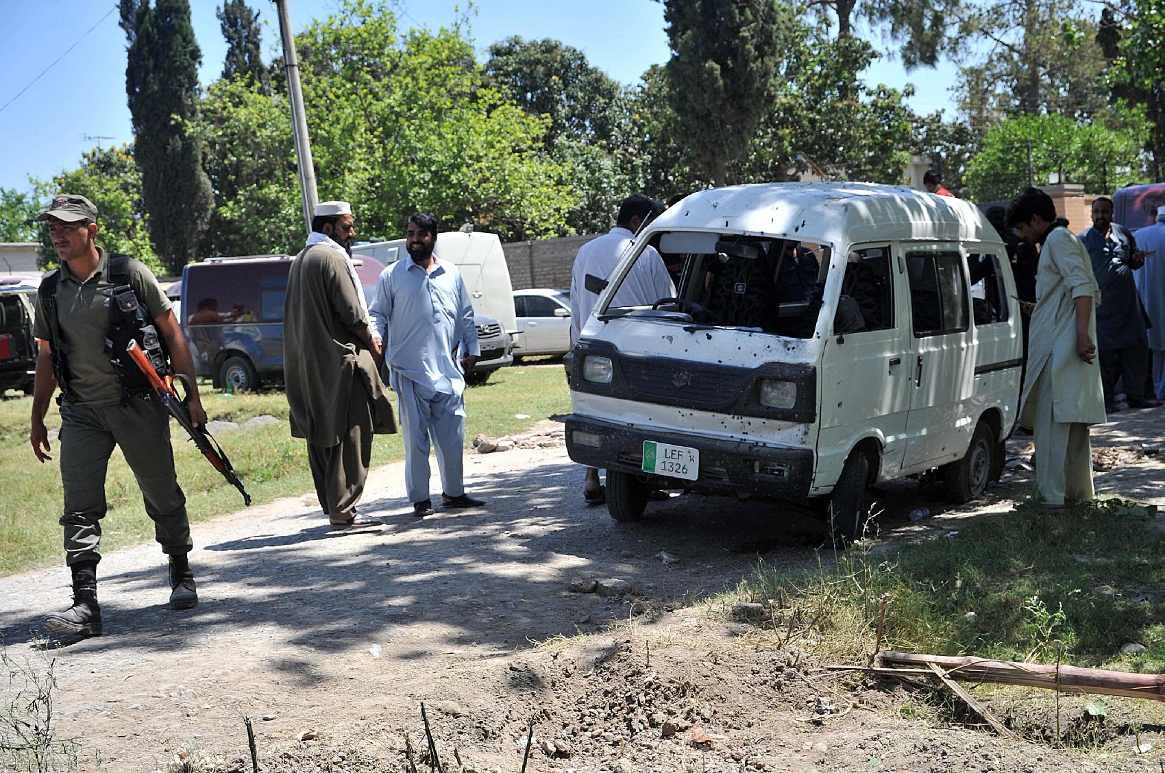 police officials inspect the site of a roadside bomb explosion in peshawar on may 18 2016 photo afp