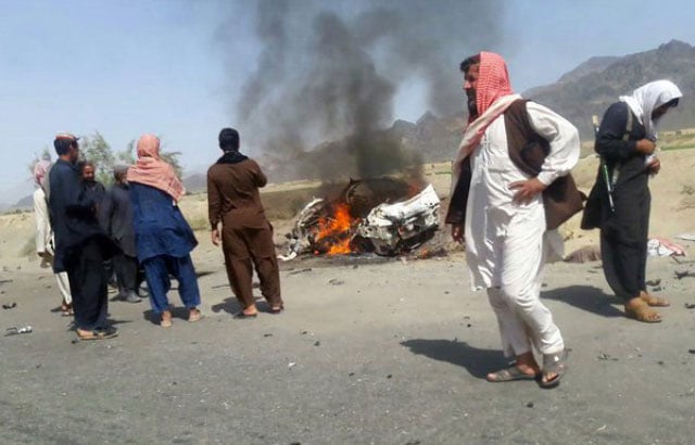 people stand near a vehicle which came under attack by a us drone near the pakistan afghanistan border on may 22 2016 photo afp