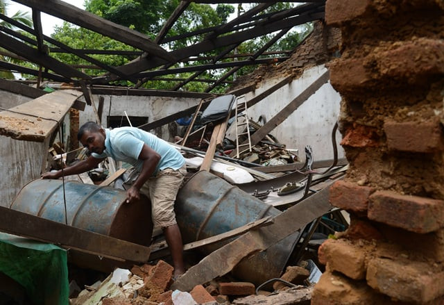 a sri lankan resident cleans up flood damage in the biyagama suburb of the capital colombo on may 23 2016 photo afp a sri lankan resident cleans up flood damage in the biyagama suburb of the capital colombo on may 23 2016 photo afp