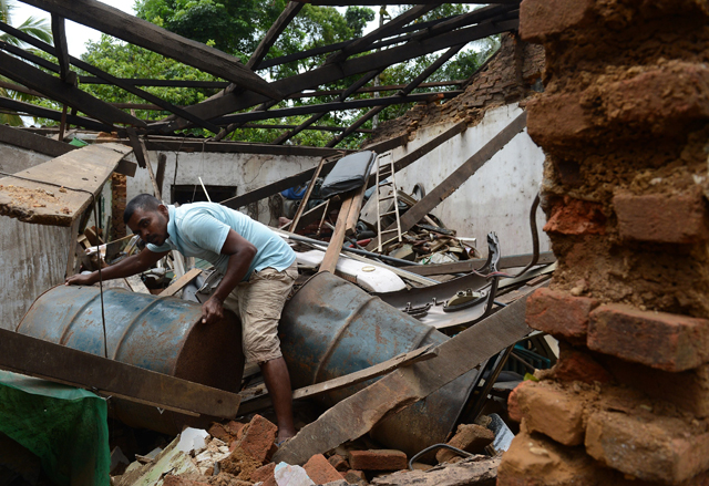 a sri lankan resident cleans up flood damage in the biyagama suburb of the capital colombo on may 23 2016 photo afp