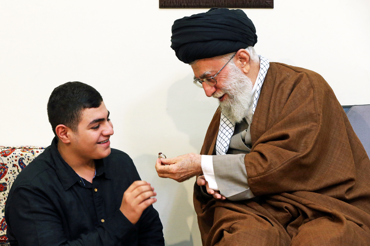 a handout picture released on may 26 2016 by the official website of the center for preserving and publishing the works of iran 039 s supreme leader ayatollah ali khamenei shows him r giving one of his rings to ali badreddine the son of mustafa badreddine a top hezbollah commander who was killed in an attack in syria as he meets with members of the badreddine family in tehran photo afp