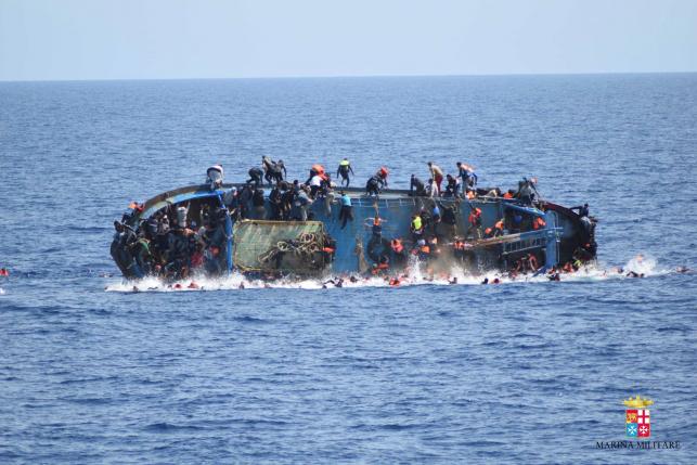 migrants are seen on a capsizing boat before a rescue operation by italian navy ships quot bettica quot and quot bergamini quot off the coast of libya in this handout picture released by the italian marina militare on may 25 2016 photo reuters