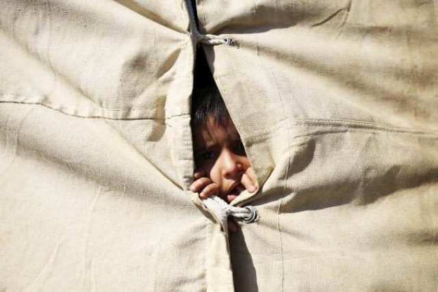 a displaced iraqi child who fled from islamic state violence in anbar looks out from inside an tent at a refugee camp near amiriyat al fallujah photo reuters a displaced iraqi child who fled from islamic state violence in anbar looks out from inside an tent at a refugee camp near amiriyat al fallujah photo reuters