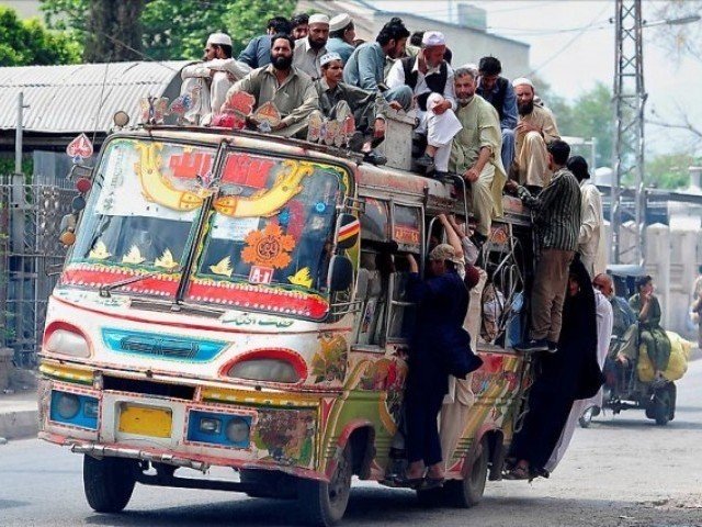a bus in peshawar teeters as passengers overburden it photo afp file