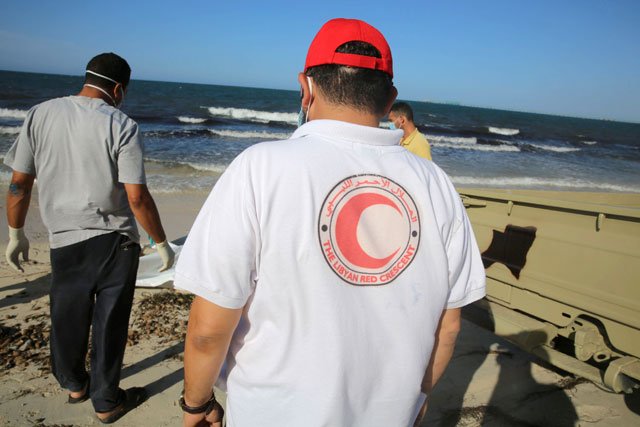 libyan red crescent workers stand beside the body of a migrant who died after a boat sank off the coastal town of zuwara west of tripoli in libya june 3 2016 photo reuters