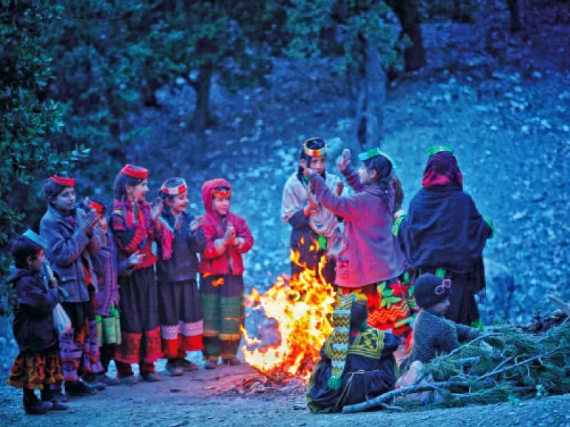 a kalash girl dances during the fire making competition as other children sing and clap in kalash valley of chitral photo express